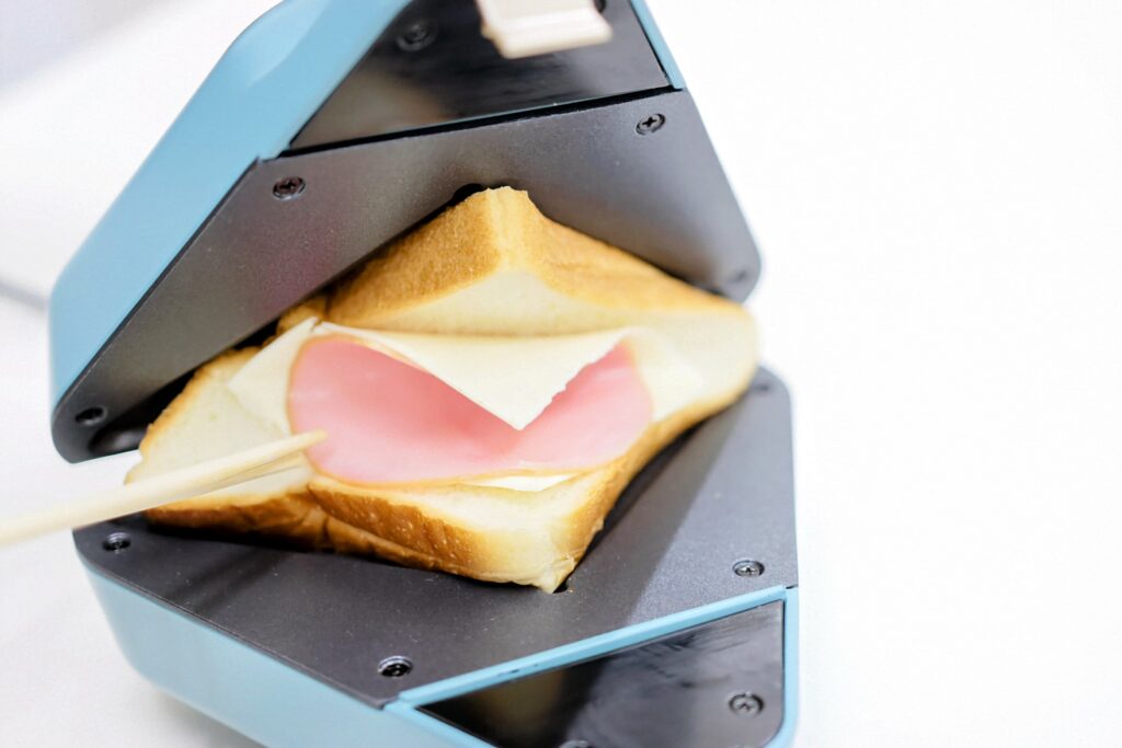 ホットサンドメーカーにのった食パンと具材を挟み込む